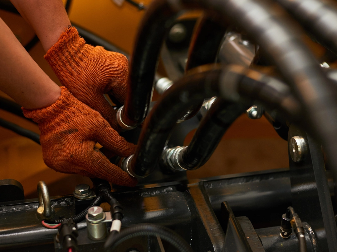 A skilled technician expertly connects hydraulic hoses, ensuring the machinery operates at peak efficiency A skilled technician expertly connects hydraulic hoses, ensuring the machinery operates at peak efficiency